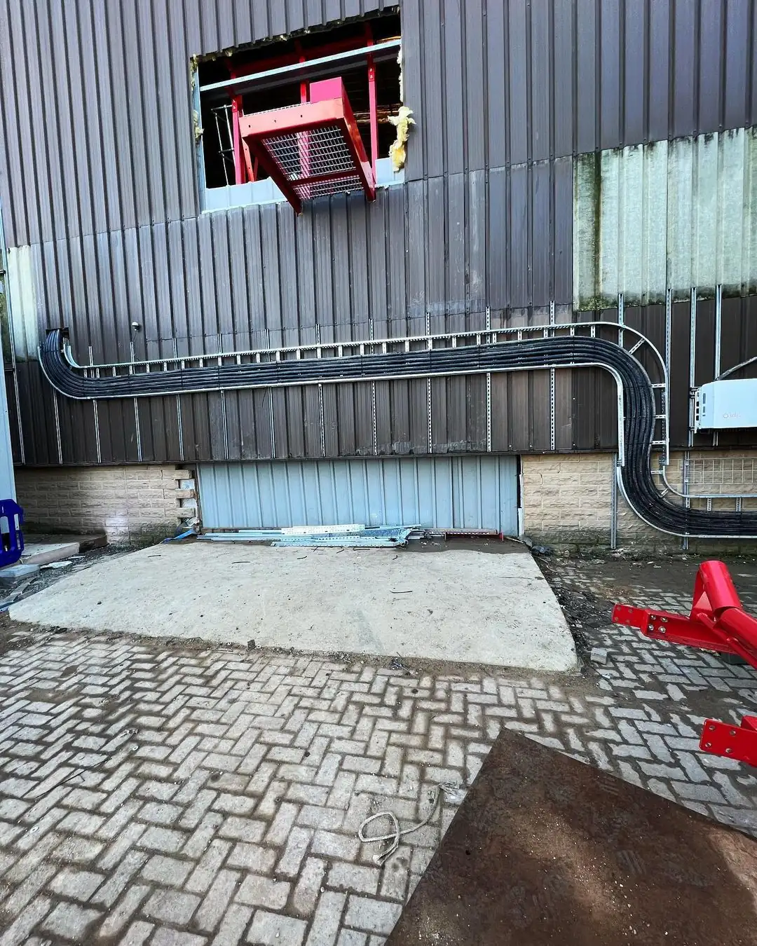 Building exterior with horizontal black cables secured by brackets