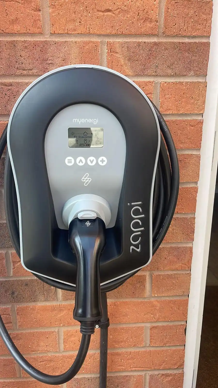 Zappi EV charger mounted on brick wall