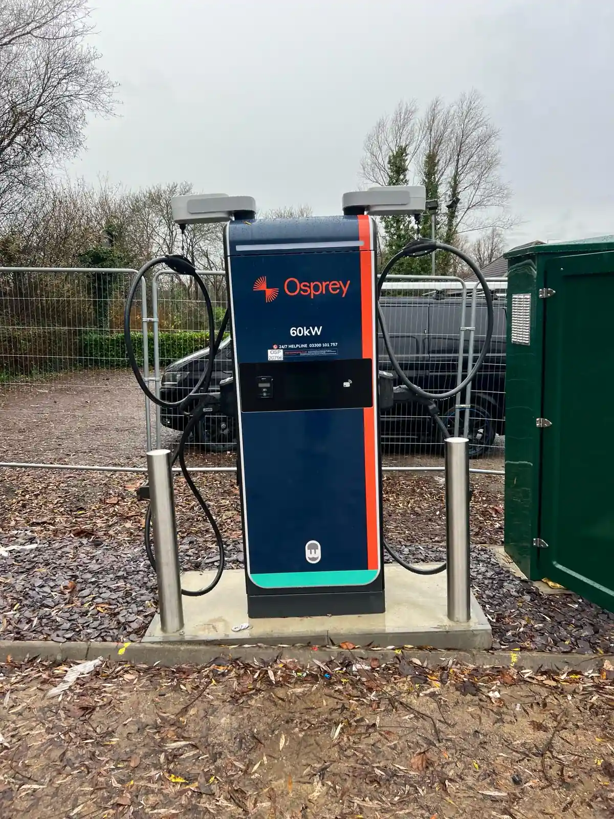 Osprey-branded EV charging station with dual connectors, installed outdoors beside green utility box