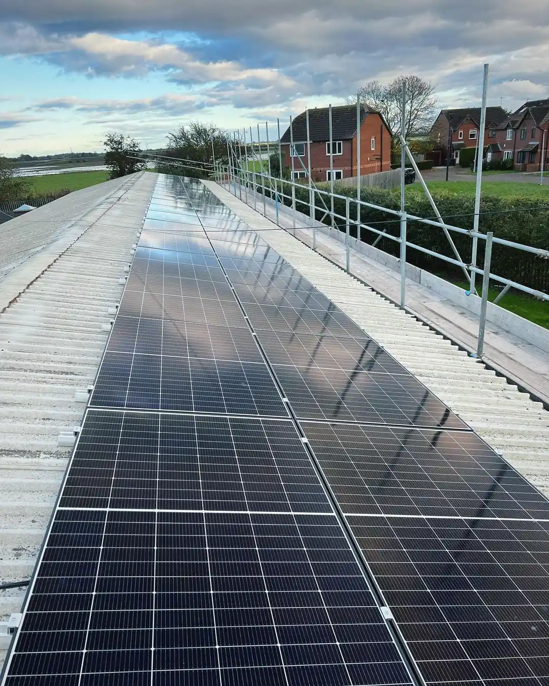 Rooftop solar panel array installed on corrugated metal roof with scaffolding